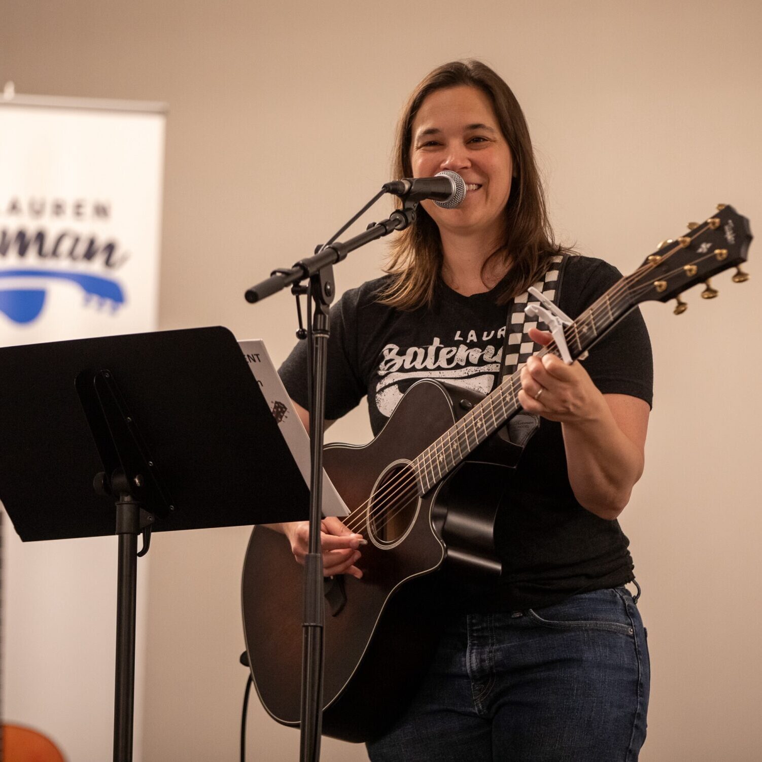 Lauren Bateman playing guitar at a microphone